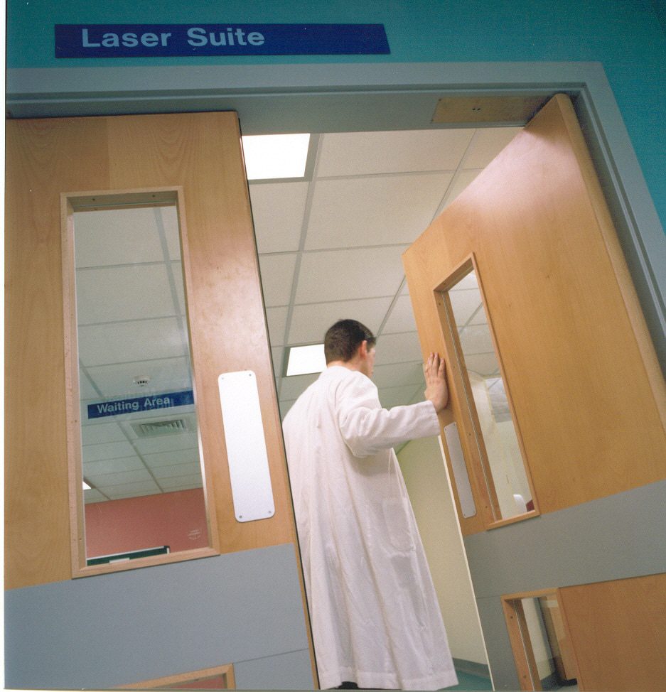 Лікар відчиняє маятникові двері з дотягувачем прихрваного монтажу