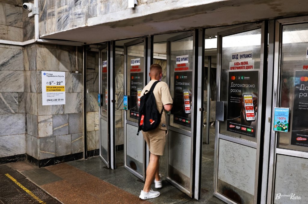 Мужчина входит в метро через распашную дверь